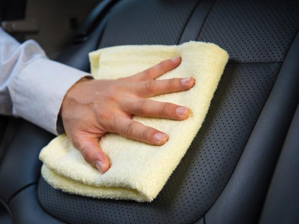 A leather cleaner is being used to clean the seats of a car.