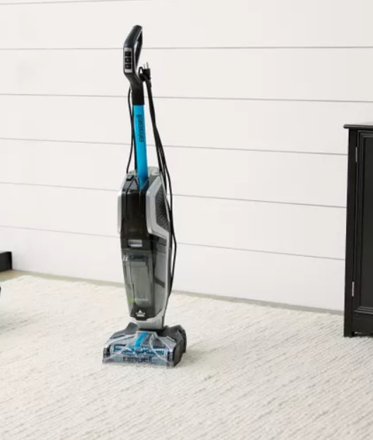 A steam cleaner is being used to clean the carpets of a car.